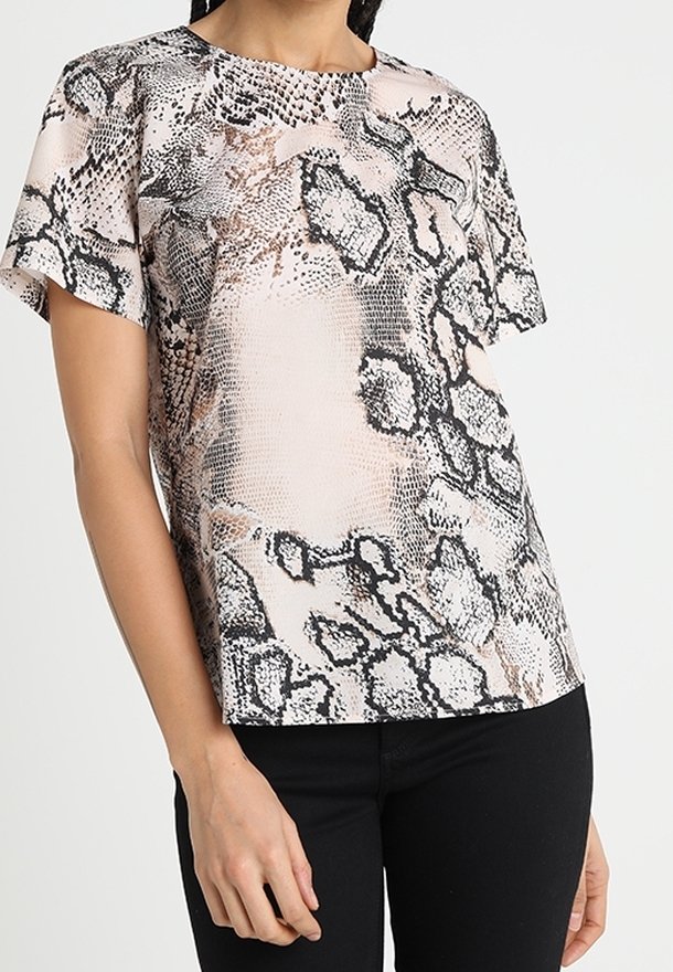 Blouse à manches courtes présentant un motif serpent rose et noir, réalisée en tissu lisse avec un col rond et une coupe décontractée.