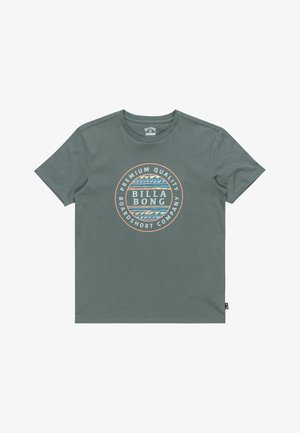 Grön bomull t-shirt med en rund grafik i mitten som visar blå och orange vågor, text: "BILLABONG PREMIUM QUALITY BOARDSHORT COMPANY".