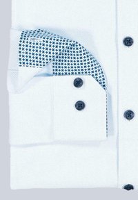 Weißes Hemdsärmeln mit einem gemusterten blauen Innenbund. Verfügt über dunkelblaue Knöpfe und strukturstoff.