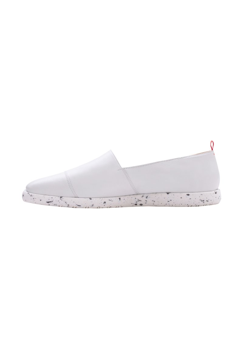 Weiße Slipperschuhe mit einem glatten Lederobermaterial, einer gesprenkelten Gummisohle und einem kleinen roten Akzent-Schlaufe auf der Rückseite.