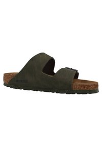 Sandale Birkenstock de culoare verde închis, cu două curele late, brant din plută și talpă din cauciuc maro. Prezintă un design minimalist cu o cataramă.