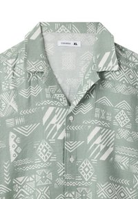 Camicia verde chiaro a maniche corte con motivi geometrici bianchi, con colletto a camicia e bottoni. Realizzata in tessuto testurizzato. Taglia XL.