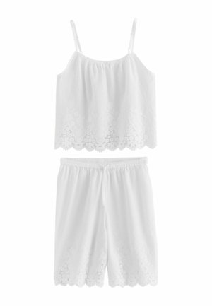 Wit katoenen mouwloos topje en knielange shortset met geborduurde golvende randen en verstelbare schouderbandjes.