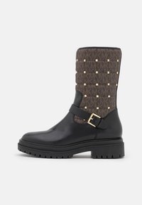 Svarta läderankelboots med ett mönstrat brunt textilöverdrag, prydda med gyllene nitar, med en sidspänne och en kraftig sula.