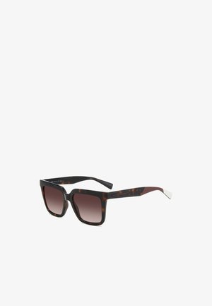 Occhiali da sole tartarugati con montatura quadrata oversize e lenti graduali marroni. Presentano un marchio discreto sulle aste e un accento argento sulla tempia.
