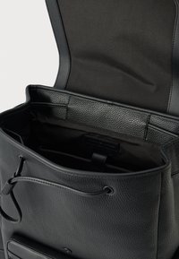 Borsa a secchiello in pelle nera con finitura testurizzata, caratterizzata da un ampio interno foderato in tessuto e un design con chiusura superiore.