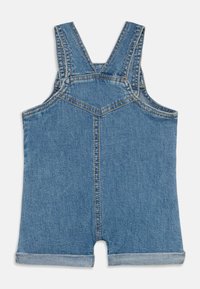 Denim kombinezoni s kratkimi hlačami z nastavljivimi naramnicami, v svetlo modri barvi, z zavitimi robovi in kontrastnim šivom ob šivih za dodaten detajl.