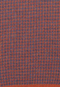 Knitted fabric in a pattern of orange and blue. The texture is smooth with a consistent, small, interlocking design.