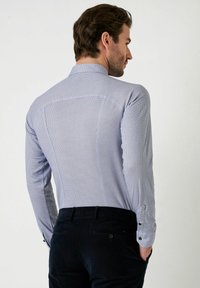 Herrenhemd in Hellblau mit Muster. Verfügt über lange Ärmel, einen Kragen und kontrastierende Knopfdetails an den Manschetten. Rückansicht sichtbar.