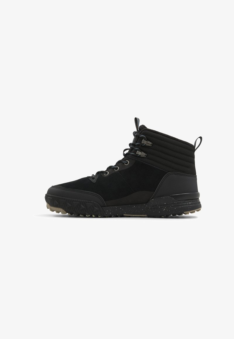 Zwarte enkellaarzen met een leren bovenwerk van suede, een gestructureerde stoffen kraag, een dikke rubberen zool met een gepatternde grip en metalen oogjes voor de veters.