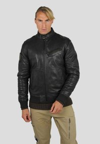 Veste bomber en cuir noir avec fermeture éclair et poignets côtelés, comprenant une poche sur la poitrine et un détail de col tricoté.