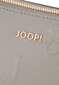 Pochette en cuir gris texturé avec fermeture éclair dorée et logo JOOP! embossé en lettres dorées sur le devant.