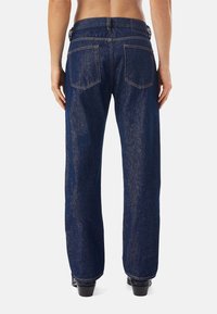 Mörkblå denimjeans med avslappnad passform och raka ben. Funktioner inkluderar två bakfickor och kontrasterande oranga sömmar.