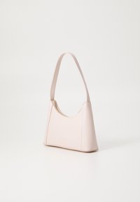 Sac à main en cuir rose avec une forme courbée, une bandoulière et une fermeture zippée sur le haut. Texture lisse et design minimaliste.