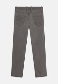 Jeans de mezclilla gris con un corte recto, que presentan una textura suave, cinturilla estándar y dos bolsillos traseros con costuras sutiles.
