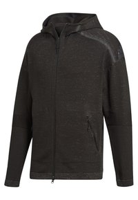 Mörkgrå zip-up hoodie med texturerad tyg, justerbar huva, sidofickor och kontrasterande paneldetaljer. Enkel, funktionell design.
