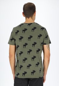 Olive green cotton t-shirt featuring a repeated black moose pattern, short sleeves, and a crew neckline.