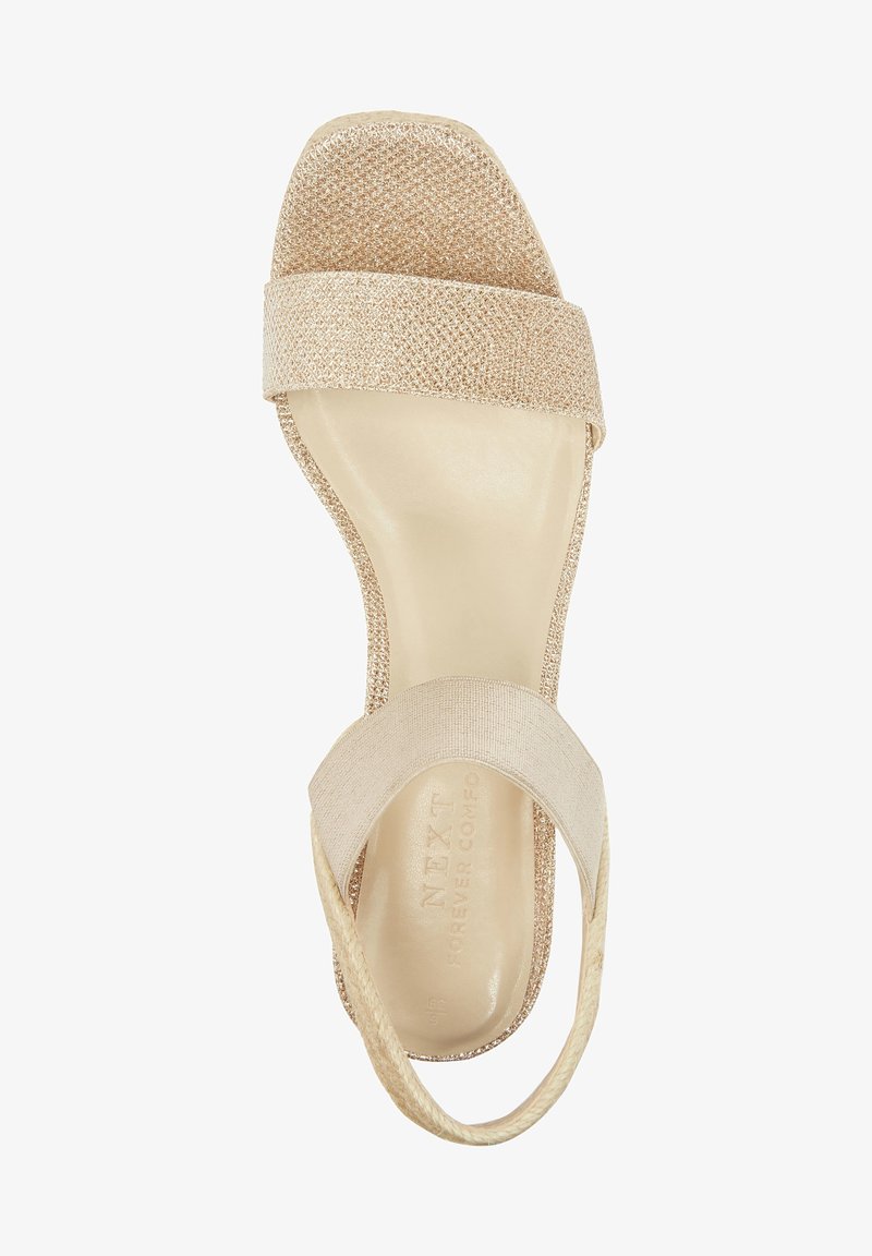 Sandales tissées beige présentant deux larges sangles, une finition texturée et une semelle lisse. Conçues pour le confort avec un petit talon.