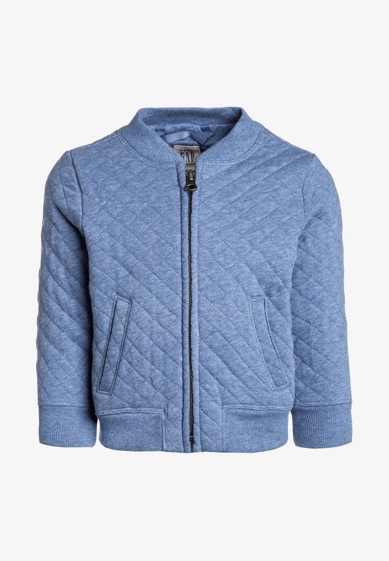 Veste matelassée bleue avec fermeture éclair à l'avant, deux poches latérales et poignets côtelés. Fabriquée dans un tissu texturé, elle présente un col rond.