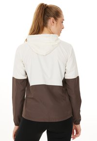 Lichte hoodie-jack met een crèmekleurig bovenste deel en een bruin onderste deel. Glad textuur met elastische manchetten en een moderne pasvorm.