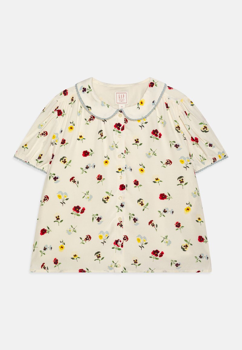 Short-sleeve, collared blouse in cream fabric with a floral pattern in red, yellow, and blue, featuring button front and ruffled sleeves.