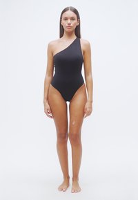 Μαύρο ολόσωμο μαγιό με σχεδιασμό ενός ώμου, ομαλή υφή, ψηλές περικοπές στα πόδια και μινιμαλιστικό στυλ. Χωρίς ορατά μεταλλικά στοιχεία ή σχέδια.