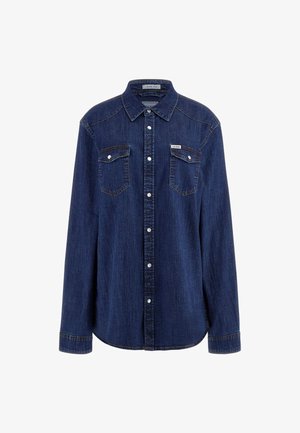 Camisa de mezclilla azul oscuro con mangas largas, cierre de botones a presión, dos bolsillos en el pecho y cuello. Presenta detalles de costura sutiles y un corte relajado.