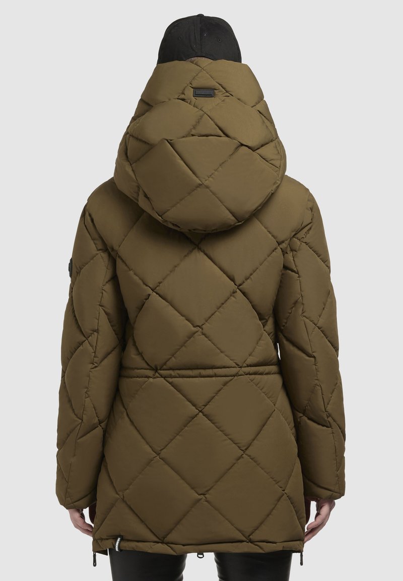 Cappotto imbottito a sacco verde oliva con cappuccio, caratterizzato da cuciture diagonali, vita alta e un berretto nero. Tessuto liscio con finitura opaca.