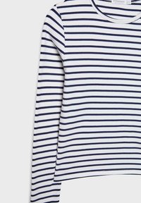 Dugmad bez rukava izrađen od mekanog materijala s horizontalnim prugama u mornarsko plavoj i bijeloj boji. Okrugli izrez i opušteni kroj s ravnim rubom.