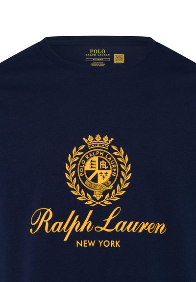Marineblauwe shirt met geel Ralph Lauren-embleem, lauwerkrans en de geschreven tekst "Ralph Lauren New York" in het midden op de voorkant.