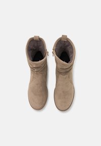 Taupe Wildleder-Stiefeletten mit strukturiertem Äußeren, glattem Innenfutter und einem seitlichen Reißverschluss für ein einfaches An- und Ausziehen. Mit einer gesteppten Sohle.