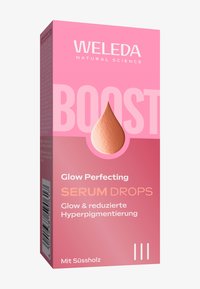 Opakowanie serum Weleda Glow Perfecting Drops ma jasnoróżowe pudełko z akcentem w kształcie kropli, na którym widnieje nazwa produktu oraz szczegóły.