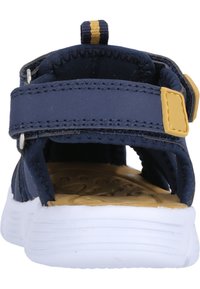 Merinavärinen tekstiilisandaali, jossa on säädettävät remmit, voimakas kantapääkuppi ja teksturoitu vaalea sisäpohja. Valkoinen kumipohja, jossa on urat pitoa varten.