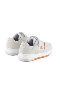 Graue Sportschuhe aus Mesh und Wildleder, mit orangen Akzenten und Klettverschluss, ausgestattet mit einer weißen Sohle mit orangefarbenen Details.