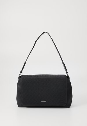 Sac à main noir en matériaux lisses et texturés, avec un rabat avant plat, une bandoulière et des détails de logo subtils.