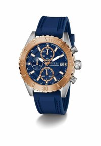 Montre chronographe bleue avec des accents en or rose, dotée d'un cadran texturé, de trois sous-cadrans et d'un affichage de la date sur un bracelet en caoutchouc bleu.