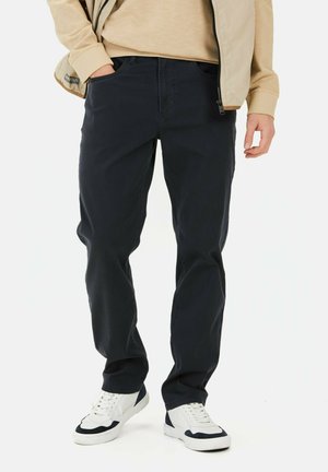 Mørkeblå bukser lavet af en bomuldsblanding, med lige bendesign og frontlommer. Kombinationen med hvide sneakers giver et afslappet look.