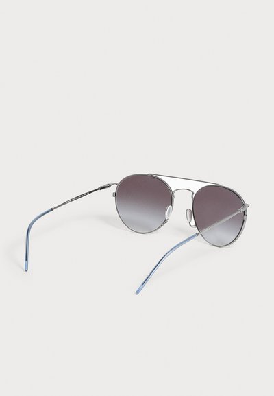 Ασημένια μεταλλικά γυαλιά ηλίου aviator με σκούρους φακούς με διαβάθμιση και λεπτούς βραχίονες με μπλε άκρες σε λευκό φόντο.