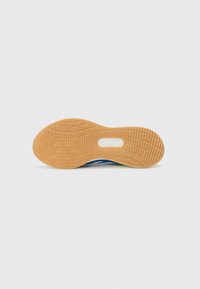 Schuhsohle mit einer strukturierten Gummi-Oberfläche. Verfügt über ein blaues und grünes Design mit einem weißen Rand. Gebogene Form mit einem zentralen Ausschnitt.