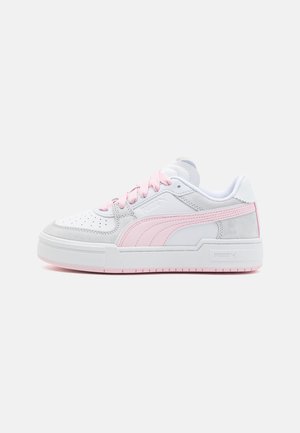 Weiße und hellrosa Sneakers mit einem Obermaterial aus glattem Leder, Wildlederelementen, perforierter Zehenpartie und einer dicken weißen Sohle. Rosa Schnürsenkel runden das Design ab.