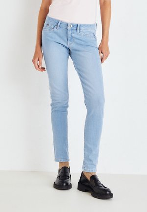 Světle modré džíny skinny s pěti kapsami, s knoflíkovým zapínáním a jemným vyblednutím. V kombinaci s černými slip-on botami.