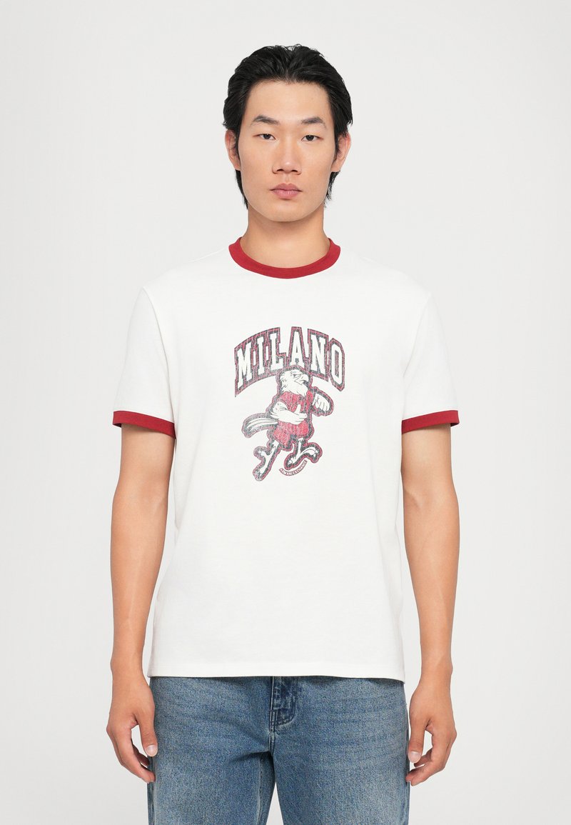Hvid bomulds t-shirt med rød ribbet krave og ærmer, prydet med et trykt "MILANO" grafik med en løve og bølgede detaljer.