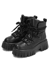 Bottes de cheville noires en cuir avec une semelle épaisse et striée. Comprend un collier rembourré, un laçage à l'avant et deux tirants sur les côtés.