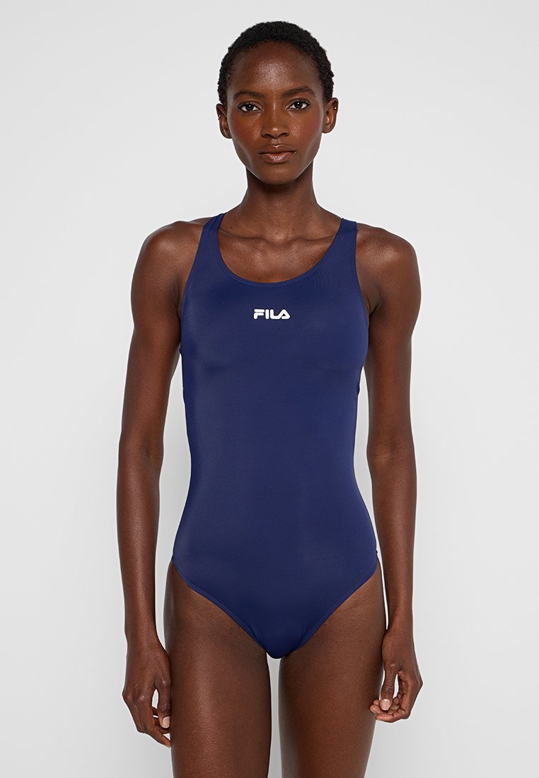 Granatowy jednoczęściowy kostium kąpielowy wykonany z gładkiego, elastycznego materiału. Posiada dekolt w serek oraz logo Fila na piersi.
