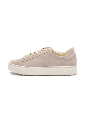 Beige suède lage sneaker met veters aan de voorkant en dikke gebroken-witte rubberen zool, weergegeven vanaf de binnenkant op een witte achtergrond.