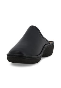 Scarpa nera in pelle slip-on con un design curvo, punta arrotondata e suola nera texturizzata. Superficie superiore liscia con dettagli di cucitura sottili.