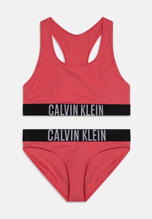 Rotes Bikini-Set von Calvin Klein mit einem Racerback-Oberteil und passenden Slips, beide mit schwarzem elastischem Bund und Logo-Detail.