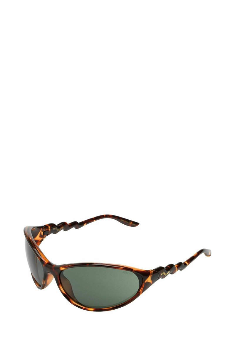 Lunettes de soleil écaille de tortue brunes avec des verres verts, de forme cat-eye courbée, et détails de branches torsadées texturées. Design de monture élégant.
