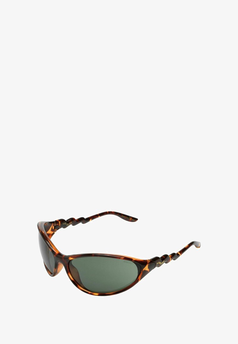 Lunettes de soleil écaille de tortue brunes avec des verres verts, de forme cat-eye courbée, et détails de branches torsadées texturées. Design de monture élégant.