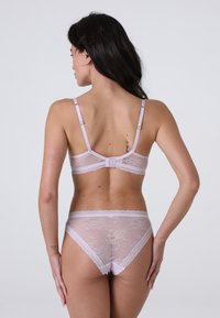 Set di lingerie in pizzo di un delicato lilla, caratterizzato da un raffinato motivo floreale e spalline regolabili. La parte posteriore presenta una chiusura a gancio e occhiello per una migliore vestibilità.